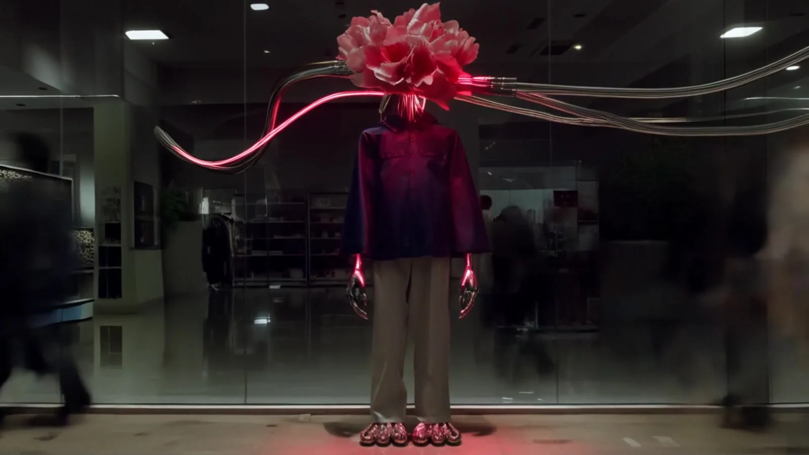 A flower-headed figure connected to luminous cables in a night-time interior.