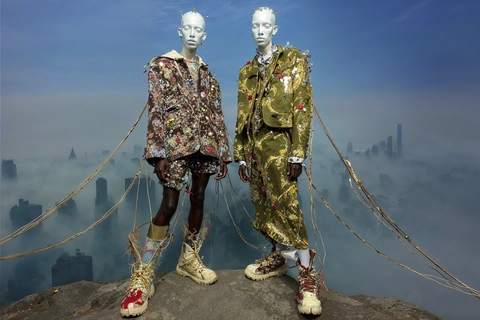 Two metallic figures above the city