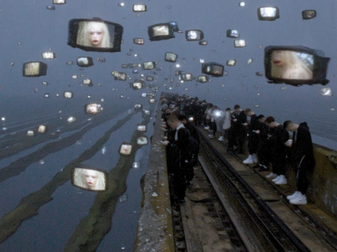 A crowd on railway tracks and televised faces