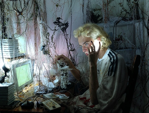 A person at a computer among cables