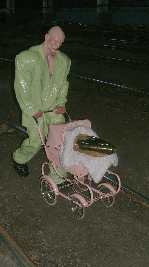 A green figure with a pink pram