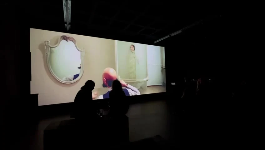 Visitors silhouetted in front of a large projection at P61 Gallery in Berlin.